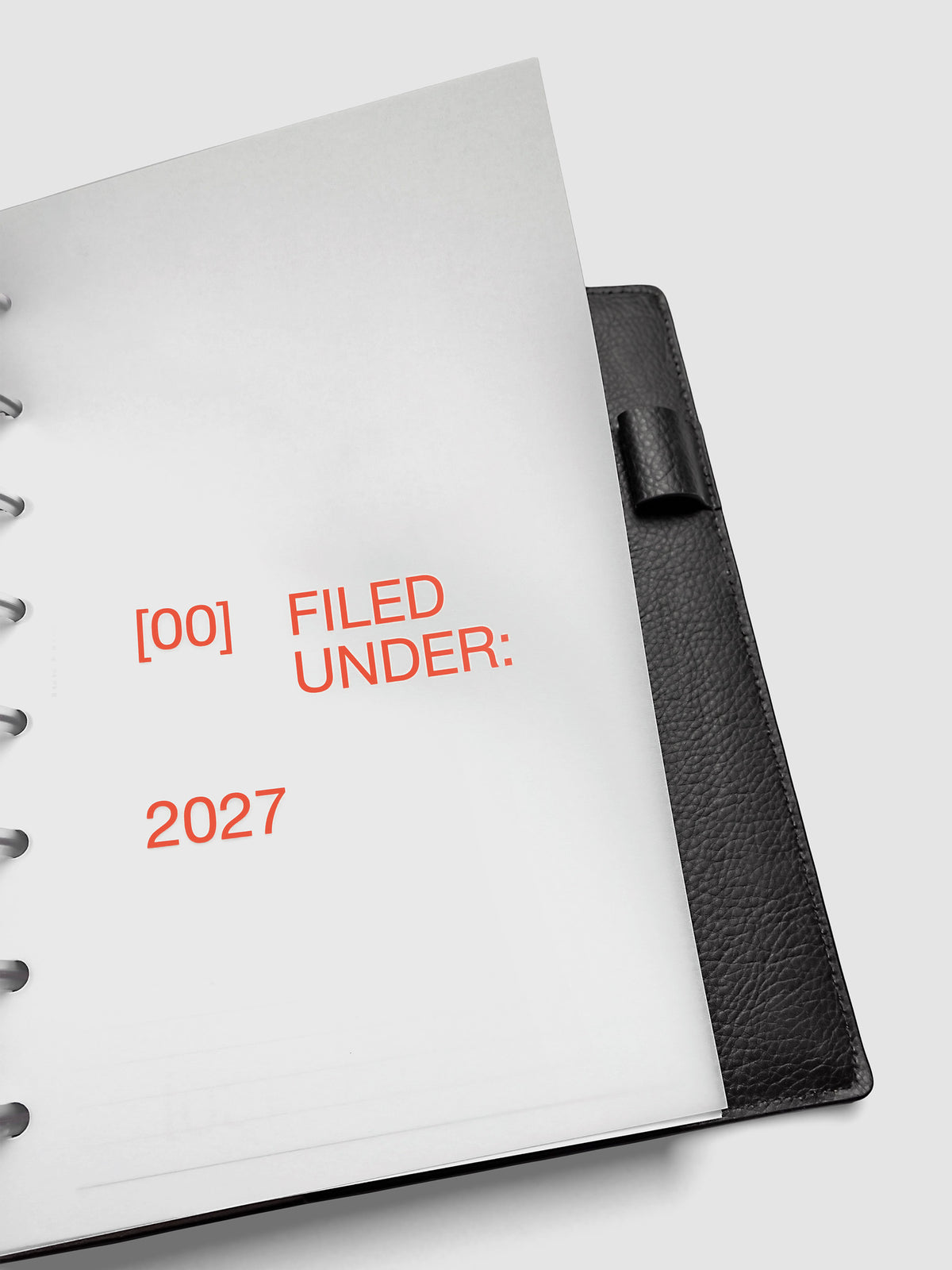 2027 Front + Monthly Dashboard Overlays, Saffron, Half Letter 8-Disc Punch, close-up of a vellum dashboard overlay lifted to show the translucent layering effect inside a planner