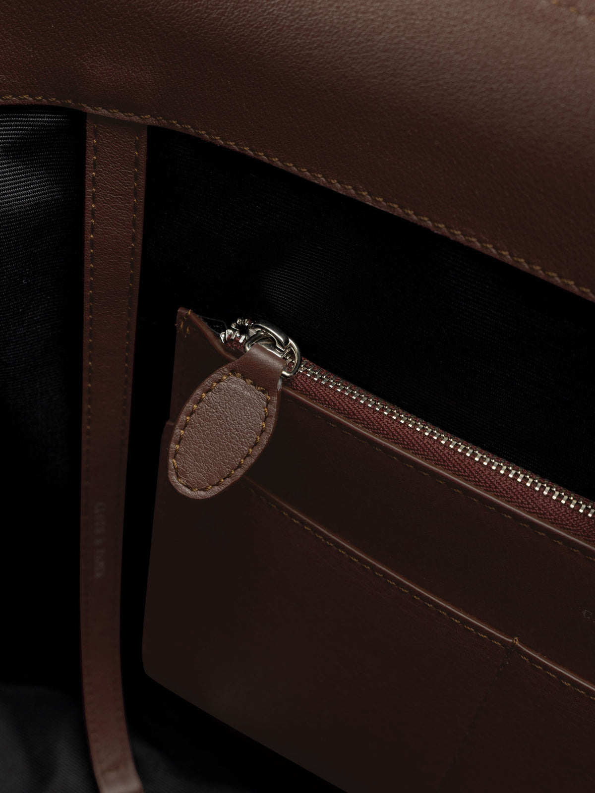 Detail view of the zip closure inner  pocket on The Metro Tote in the color Cordoba.