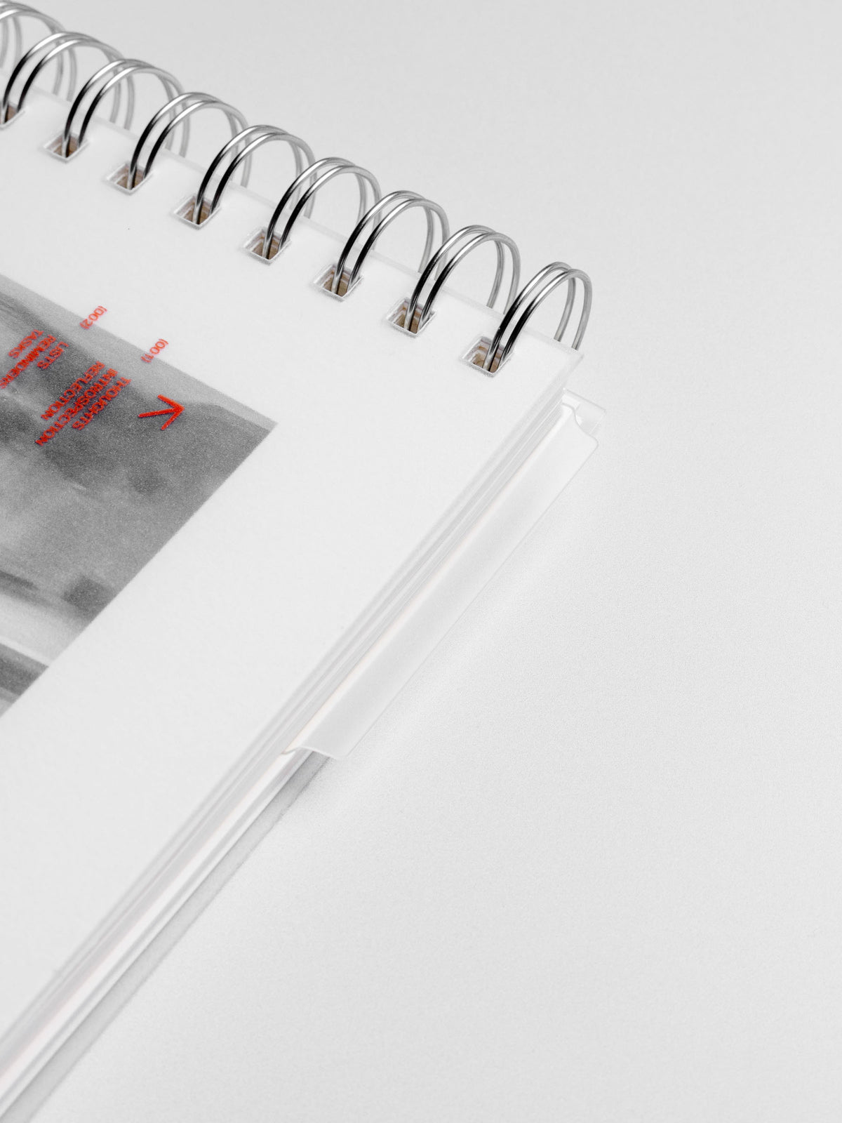 Page marker shown protruding from a closed spiral notebook.