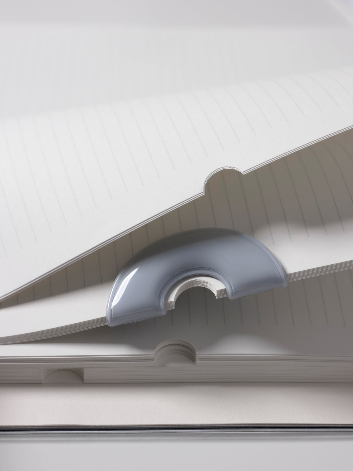 Magnetic Bookmark | Spotlight in the color Ash, a light grey, shown in use in a notebook