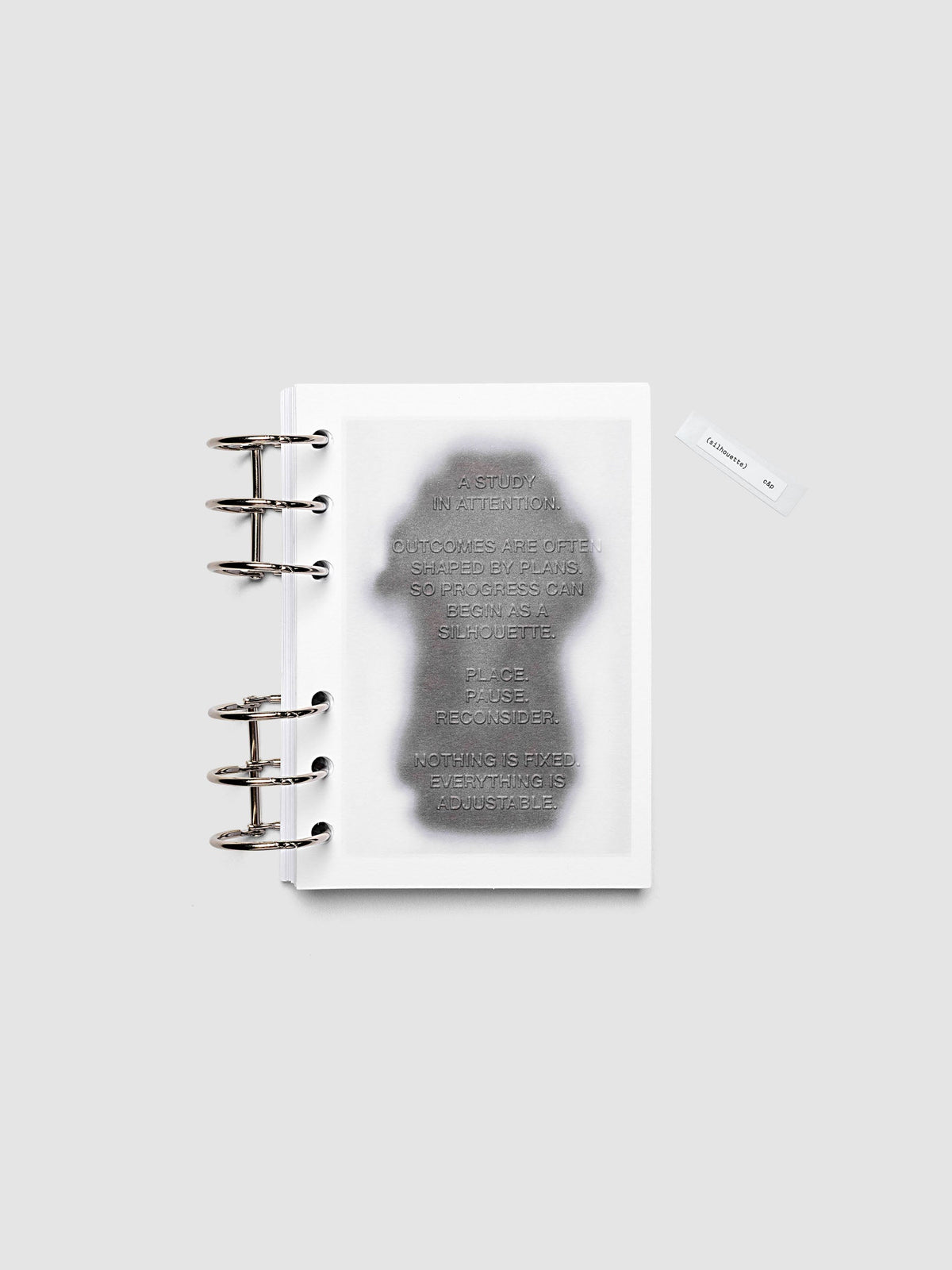 Silhouette Planner Dashboard in A6. Greyscale silhouette print with embossed text on paper. Image 2 of 2.
