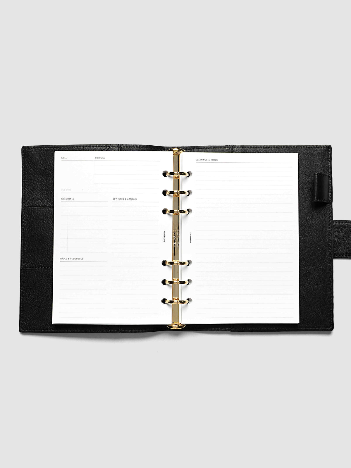 The Personal Wide Personal Curriculum Planner Inserts open in a black leather ring bound planner to a skill spread, with skill, purpose, milestones, key tasks and resources on the left and lined learnings and notes on the right