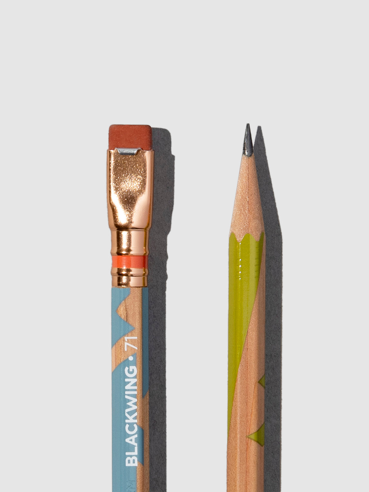 Wooden pencils with green and blue accents displayed on a neutral background.