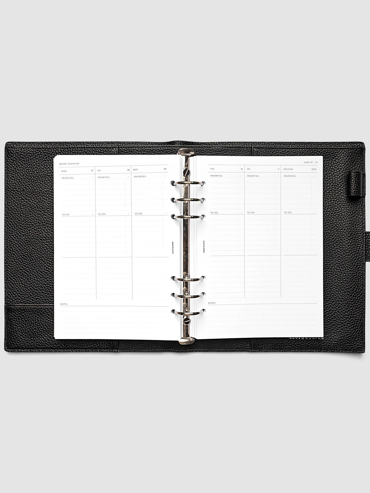 Both pages inside planner: 2027 Dated Weekly Task Planner Inserts, Monday Start, A5 6-Ring Punch, full week-on-two-pages spread showing blank vertical columns for each day with labeled priorities, to-do, and notes sections, Saturday and Sunday combined, and weekly notes section along the bottom, shown inside a planner