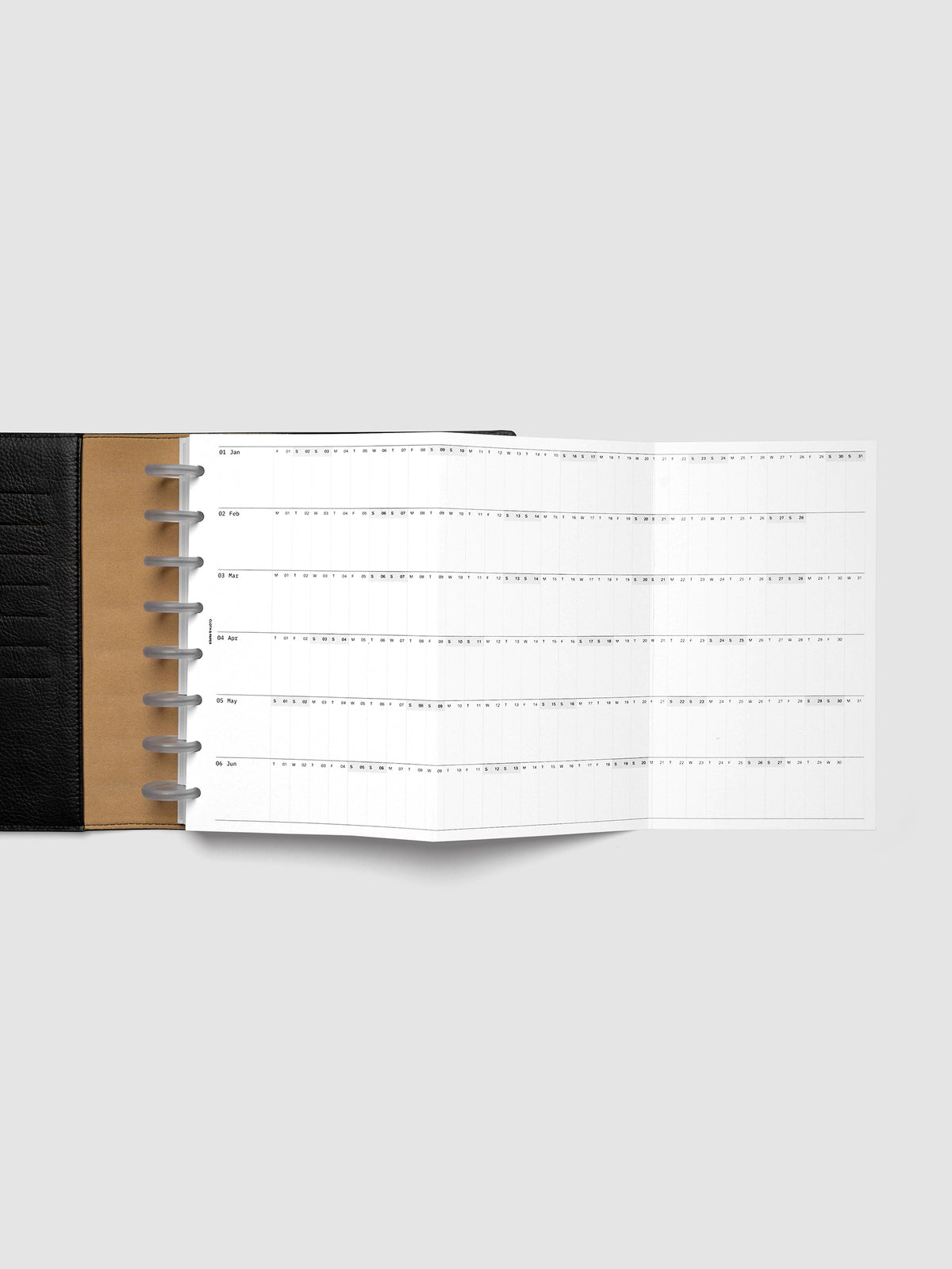 2027 Dated Fold Out Insert fully unfolded inside a Half Letter 8-Disc Punch discbound planner, showing six months of dated calendar boxes across one side.