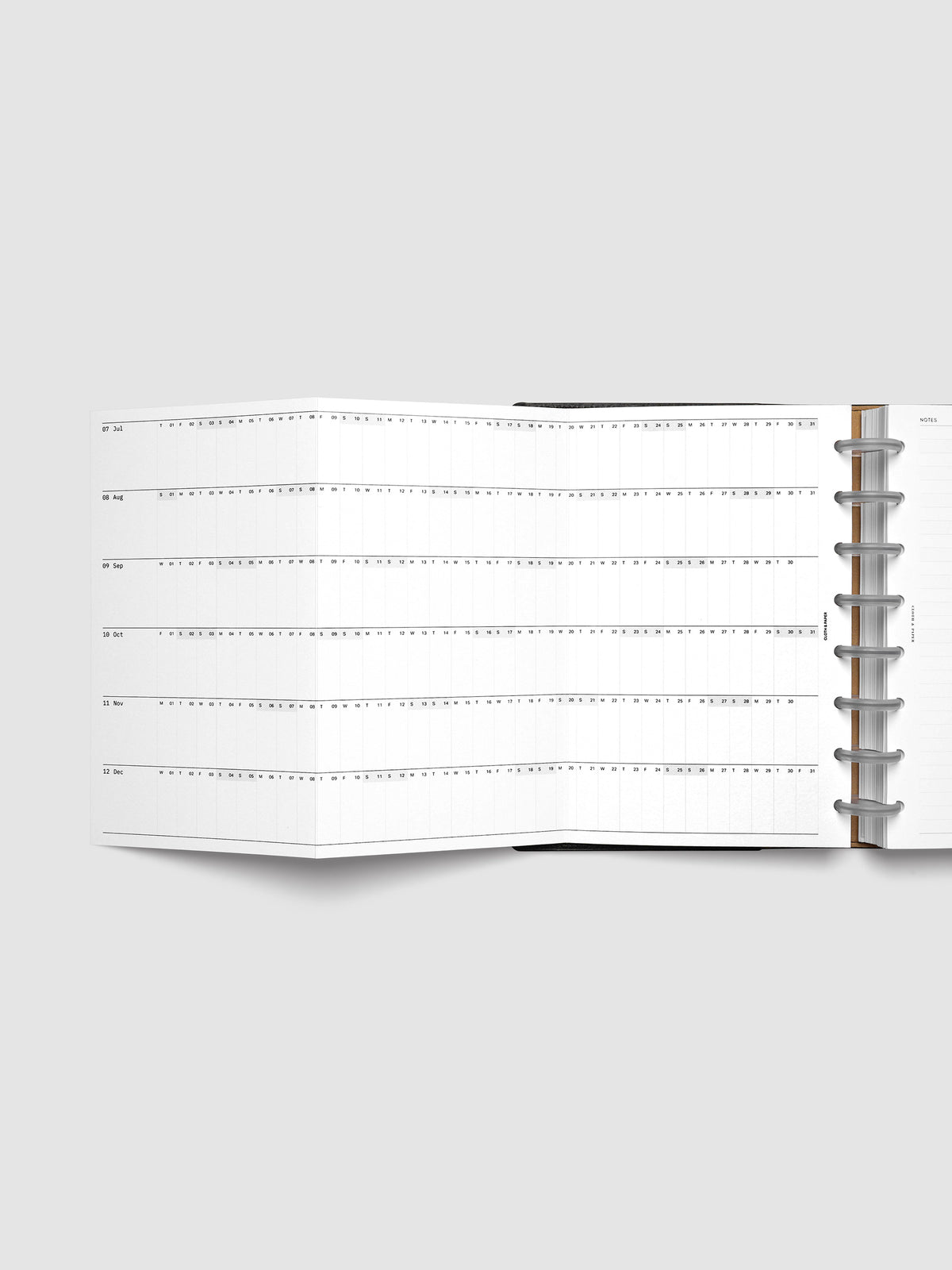 2027 Dated Fold Out Insert fully unfolded inside a Half Letter 8-Disc Punch discbound planner, showing six months of dated calendar boxes across one side.