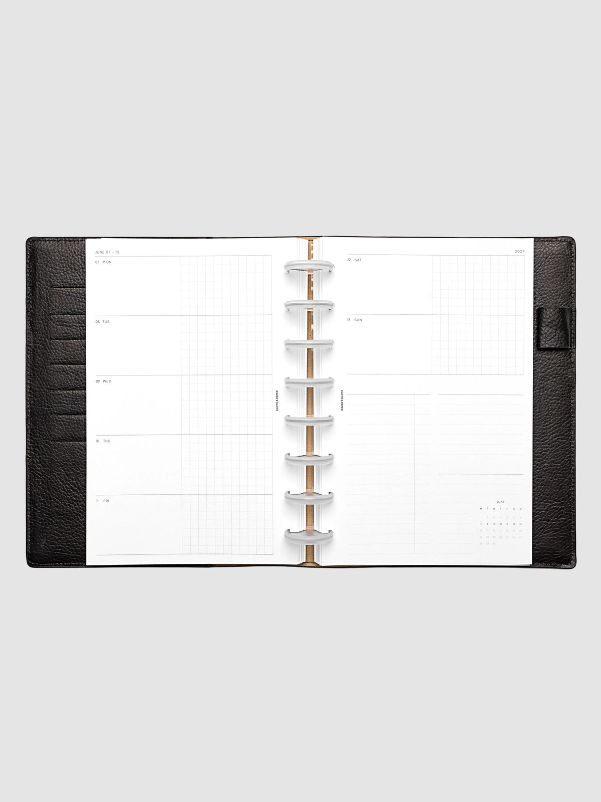 Open planner showing the full two-page 2027 Dated Weekly Horizontal Monday Start spread in Half Letter 8-Disc Punch size, with split open and graph daily columns on the left and weekend dates, tasks, notes, and mini monthly calendar on the right