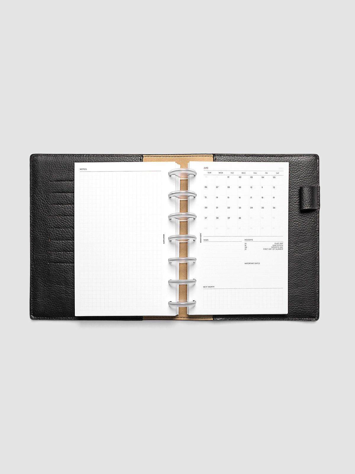 2027 Dated Monthly Admin Inserts open inside a HP Mini 7-Disc Punch discbound planner, showing the fully open graph left page alongside the Sunday start monthly calendar, task section, holiday reference, important dates, and next month preview on the right.