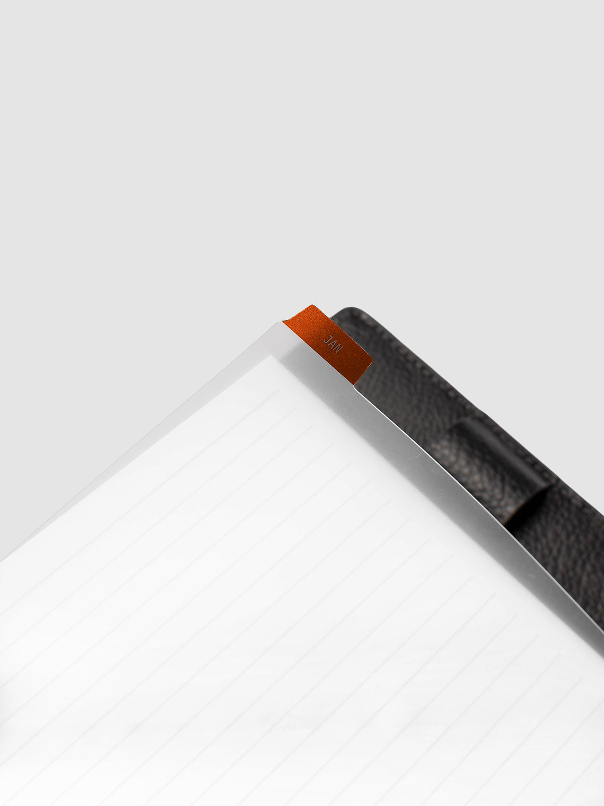 Close-up of deep orange monthly divider lifted from Half Letter 8-Disc Punch planner showing colored background and clear knockout month text