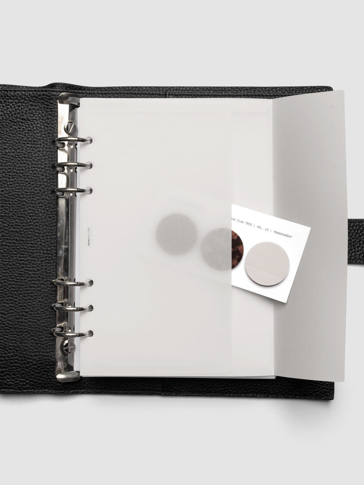 White Envelope Storage Holder shown inside a black, leather A5 agenda with page flags inside.