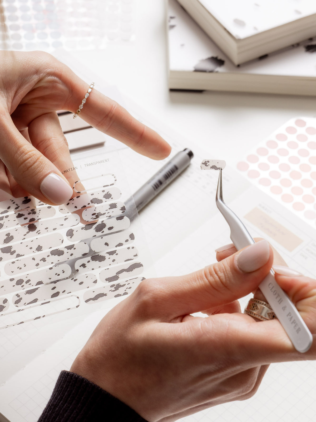 A woman applying Bar Stickers in Dalmatian with sticker tweezers