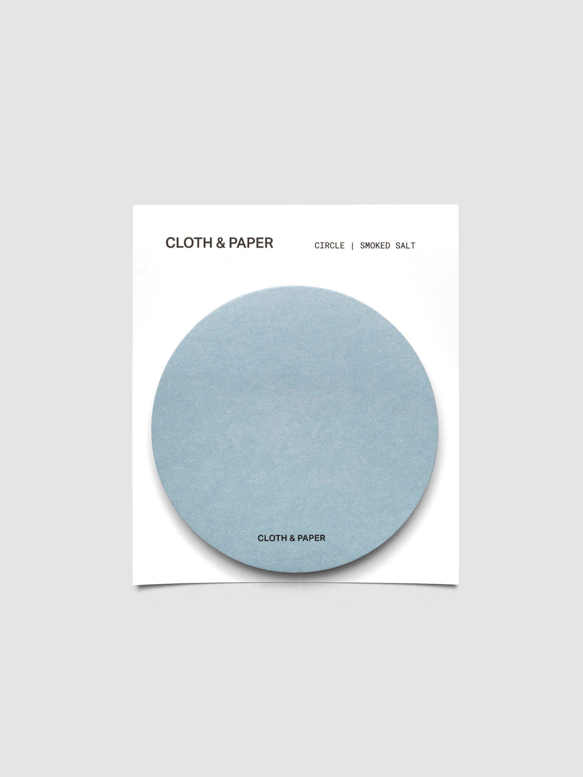 A stack of light blue circular sticky notes on a white backer card