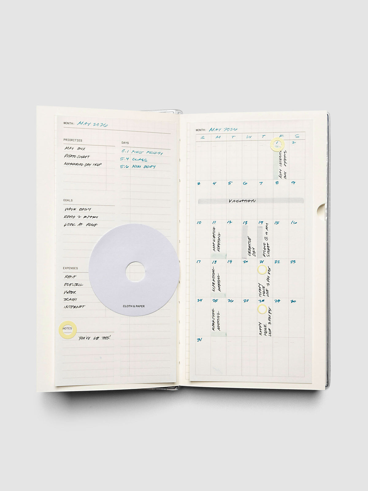Monthly overview and calendar sticky note in use in a notebook with handwritten planning notes