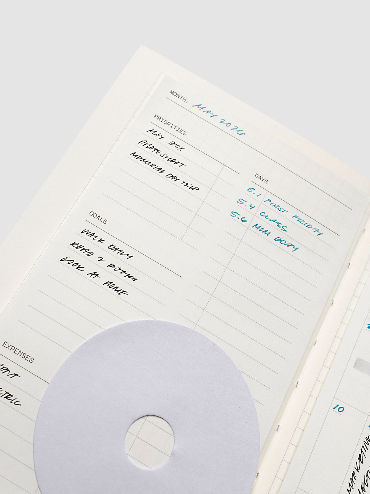 Monthly overview sticky note in use in a notebook with handwritten planning notes