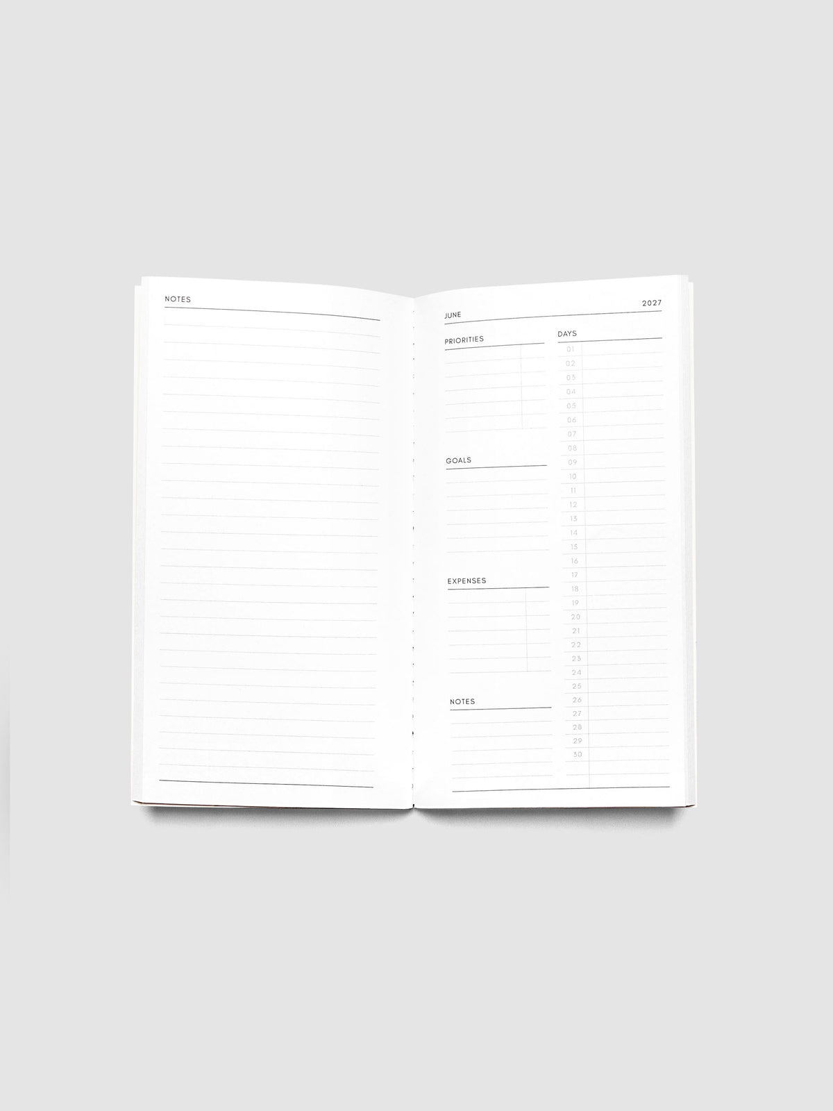 Open 2027 Dated Travel Notebook Monthly in Pocket Plus size showing the full monthly overview spread, with a notes page on the left and priorities, days, goals, expenses, and a notes section on the right