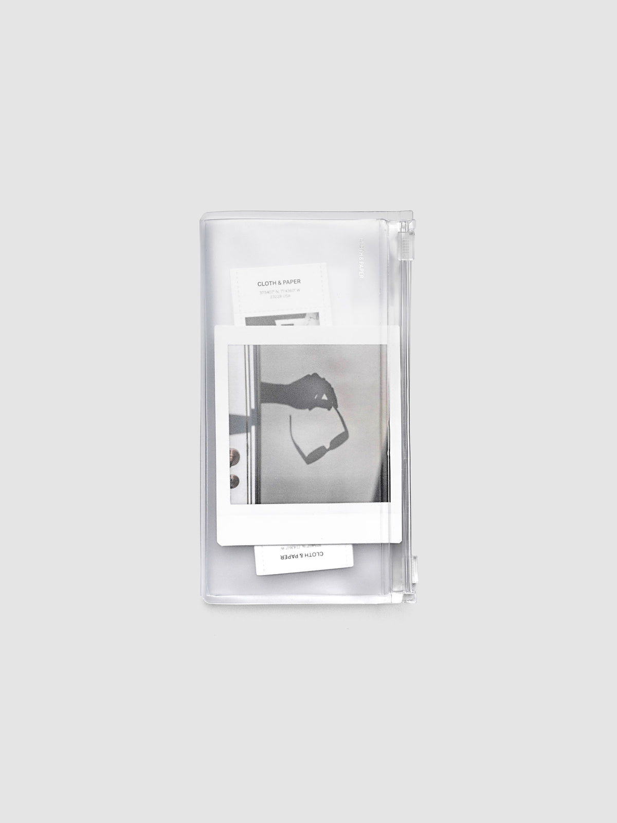 Pocket Plus travel notebook storage holder in clear frosted plastic, closed, with stickers and cards visible inside