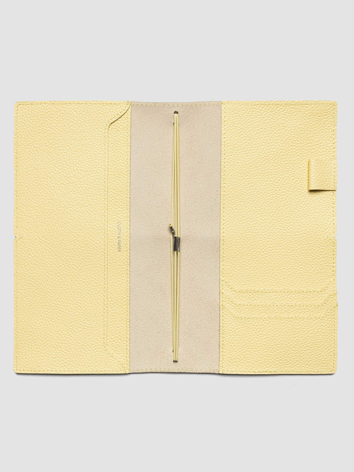 Butter yellow leather travel notebook cover in size A5 Slim shown open with interior pockes and elastic bands.