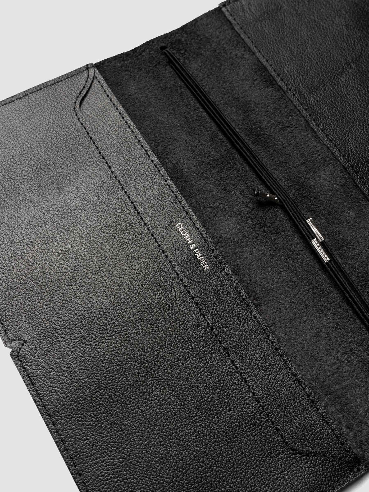 Black leather travel notebook cover in size A5 Slim shown open with interior pockes and elastic bands.