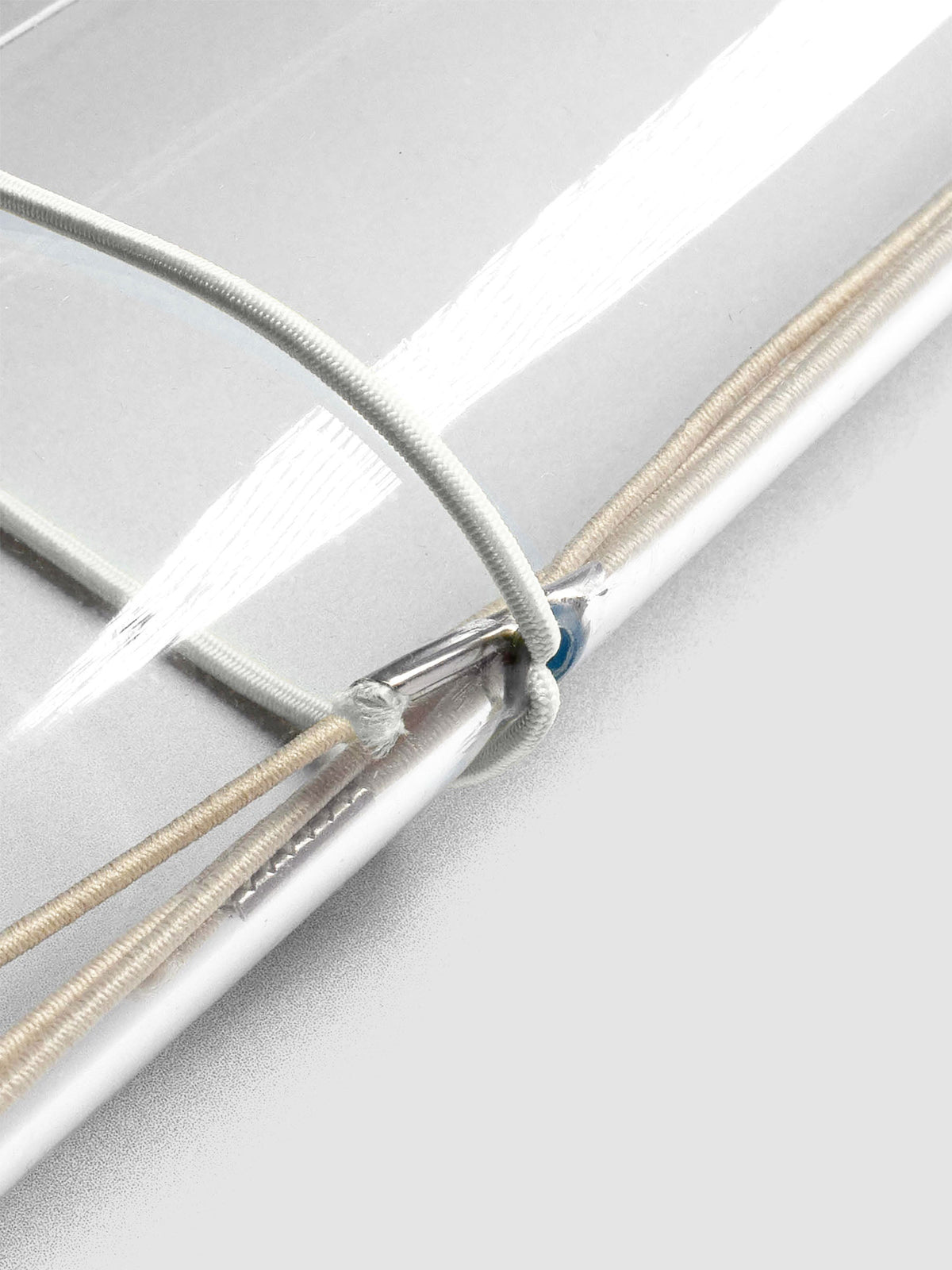 Grey elastic exterior band looped through clear vinyl travel cover spine.