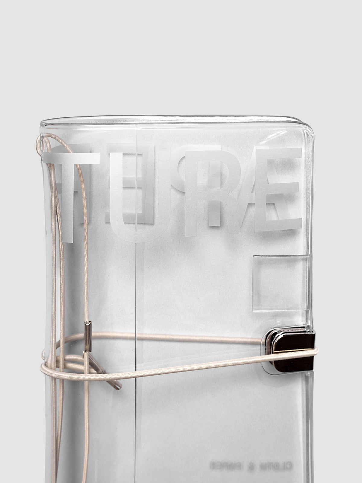 Close-up of the top of the Aperture Travel Notebook Cover in Pocket Plus size, closed, showing metal tab closure and grey band