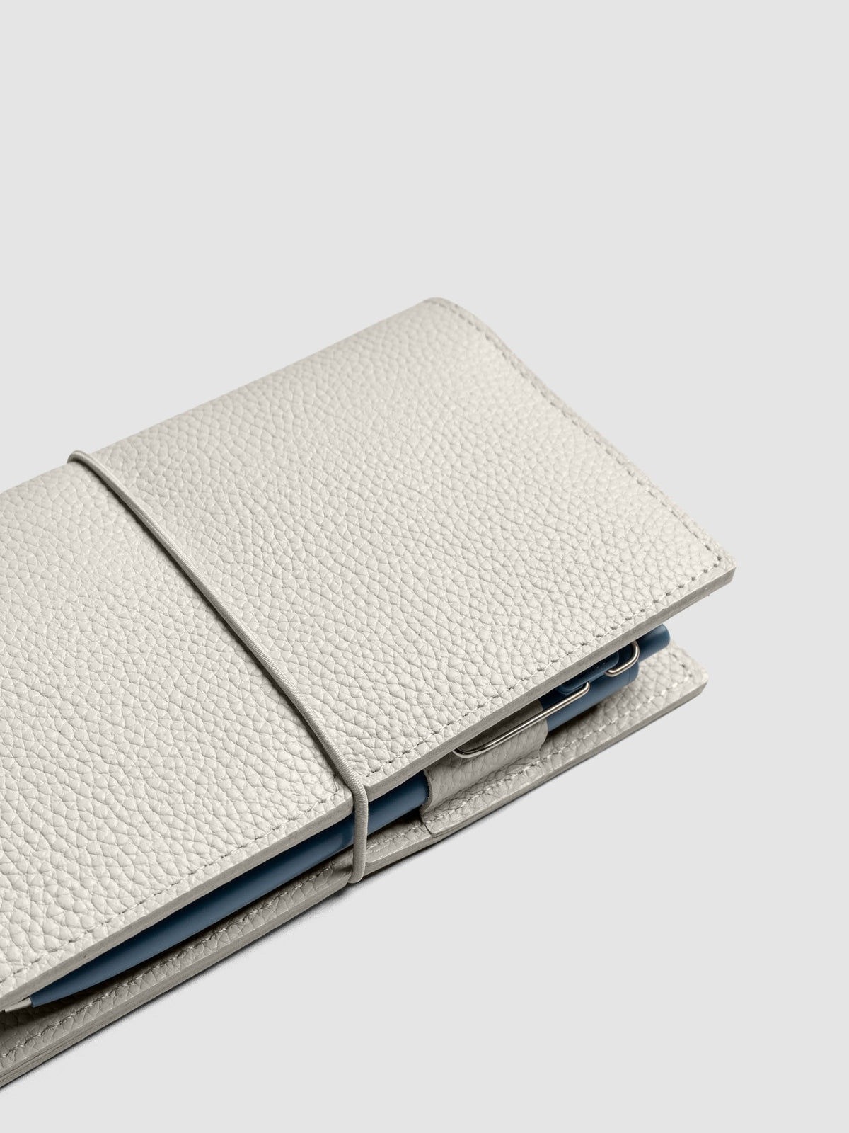 Light grey leather travel notebook cover in size Pocket Plus shown open with a pen in the pen loop.