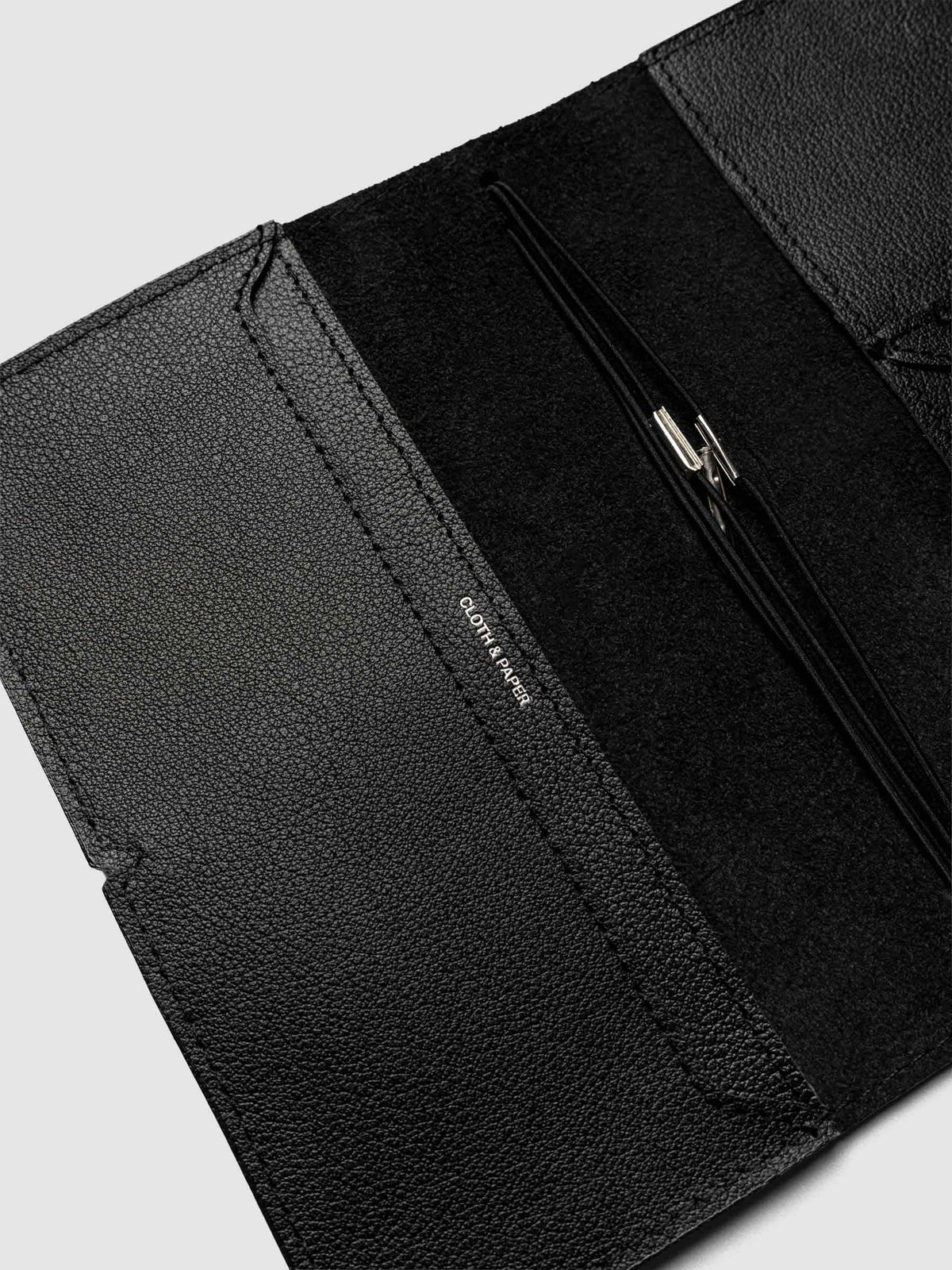 Black leather travel notebook cover in size Pocket Plus shown open with interior pockes and elastic bands.