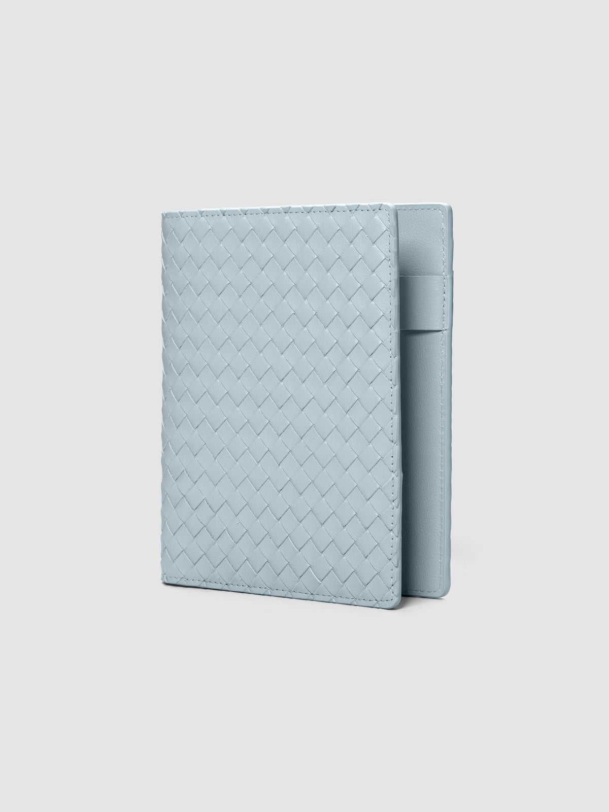Blue woven leather planner cover shown standing at an angle.