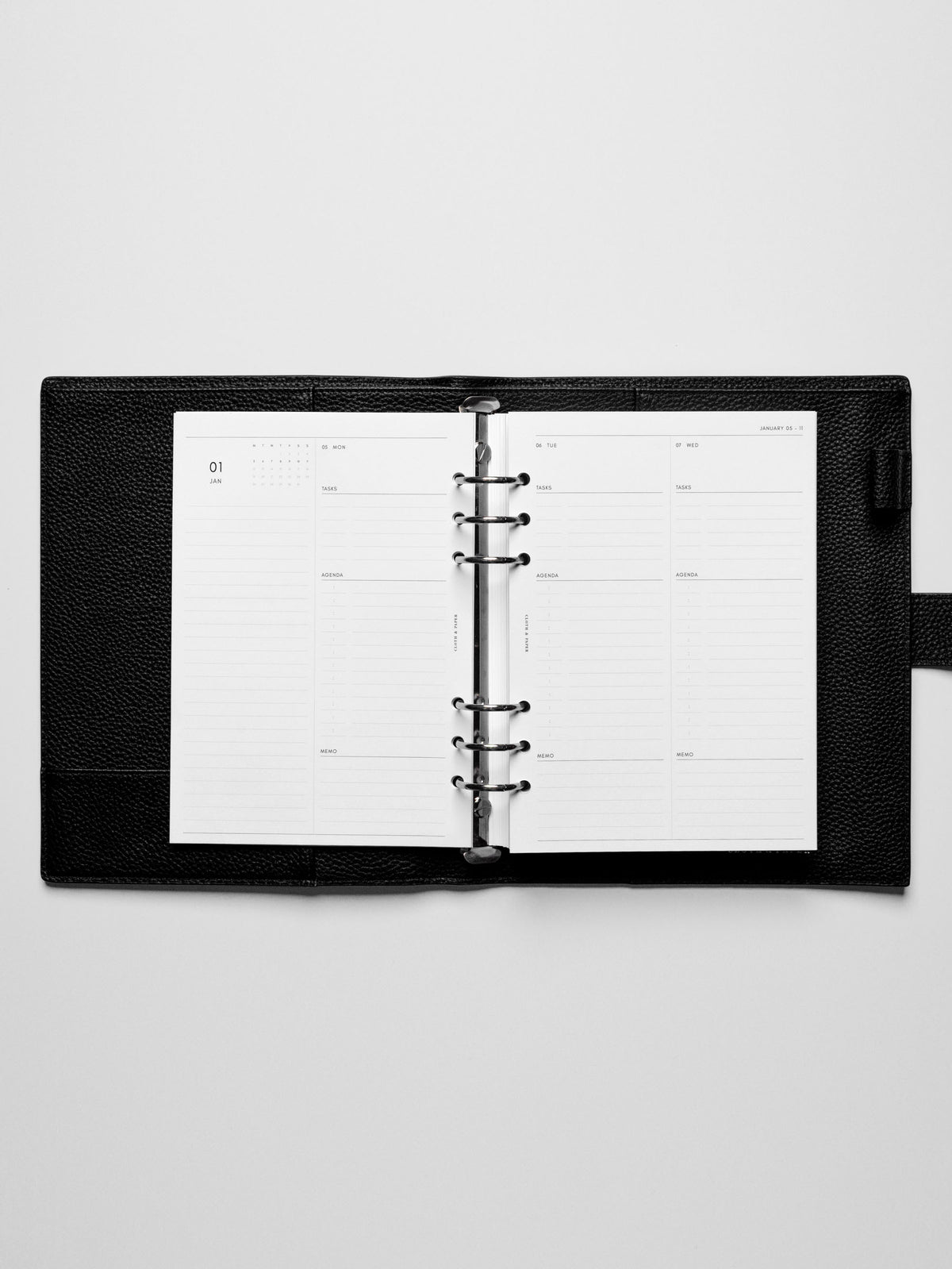 Image shows the Monday Start 2026 Dated Daily Planner Insert in a black leather ring-bound planner.