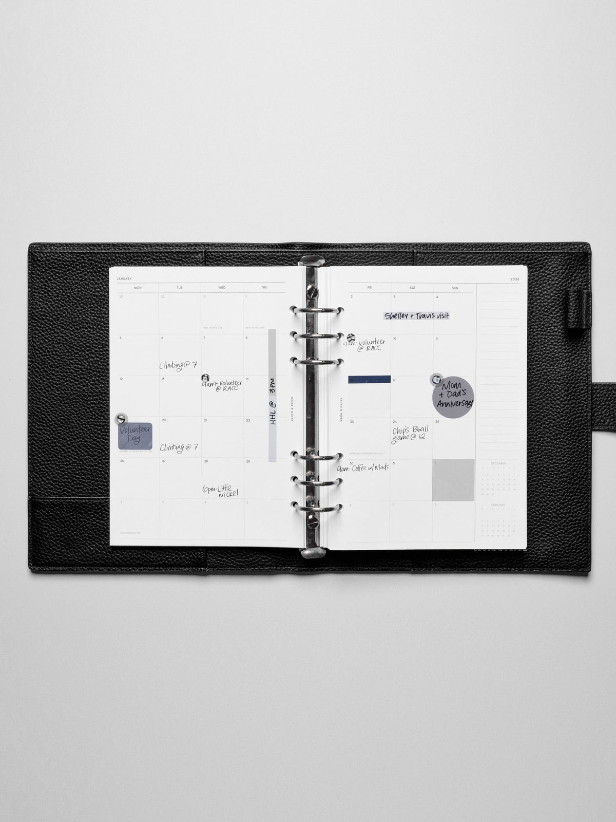 Image shows the Monday Start 2026 Dated Monthly Planner Inserts used in a black leather A5 ring-bound planner. Stickers and sticky notes highlight the notes.