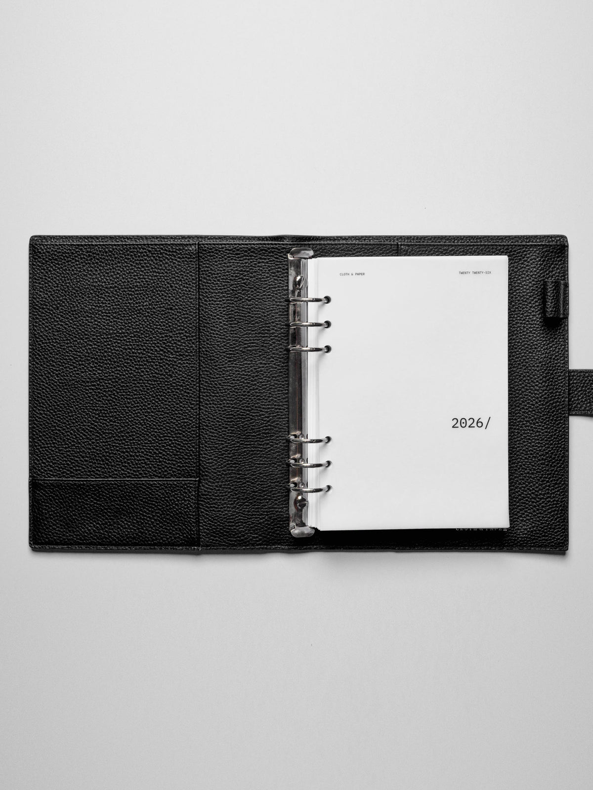 Image shows the 2026 front cover used in a black leather A5 ring-bound planner.
