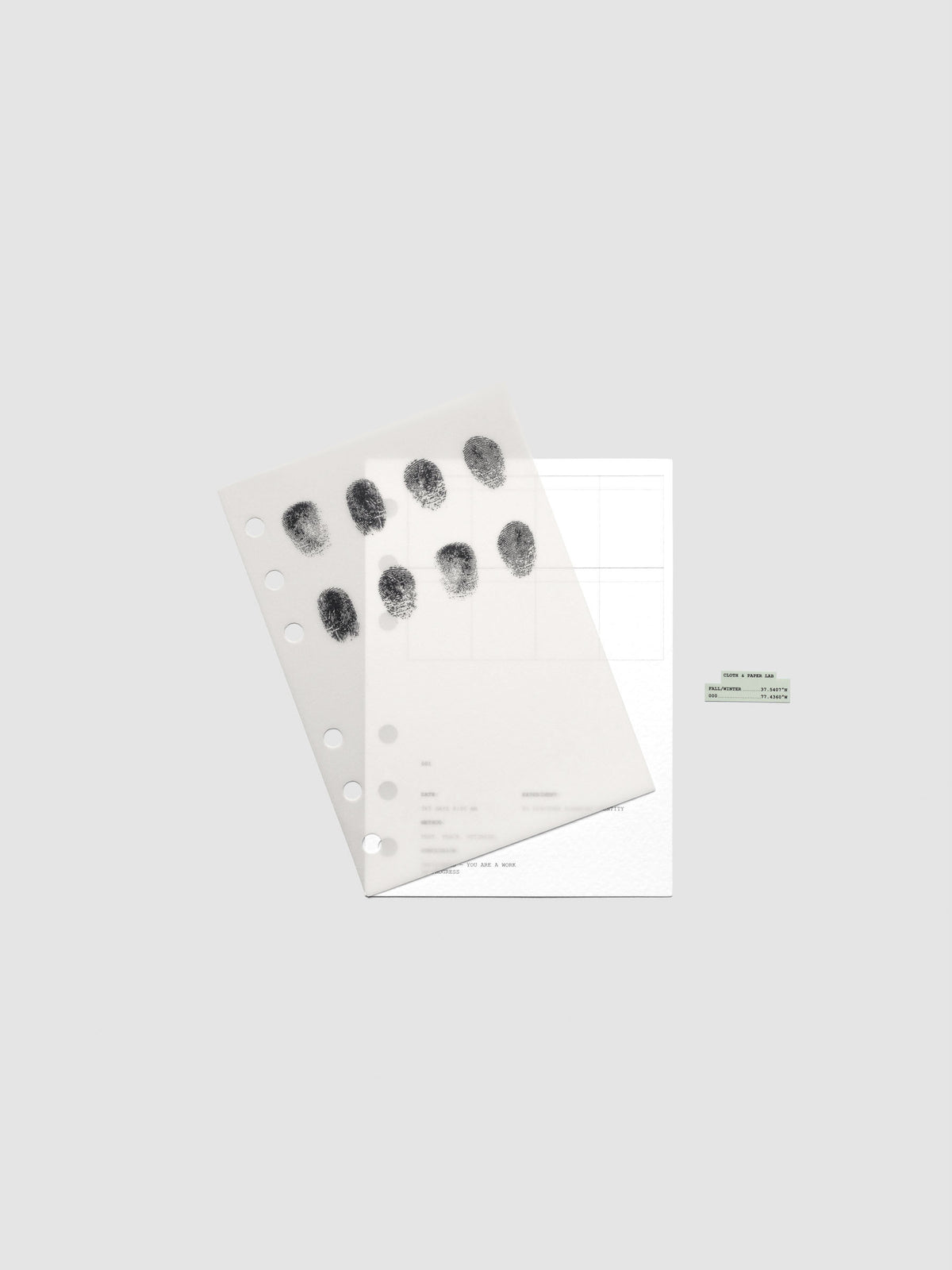 Two layered A6 sized planner dashboards, one semi-transparent, one matte, featuring a fingerprint design shown offset from one another.