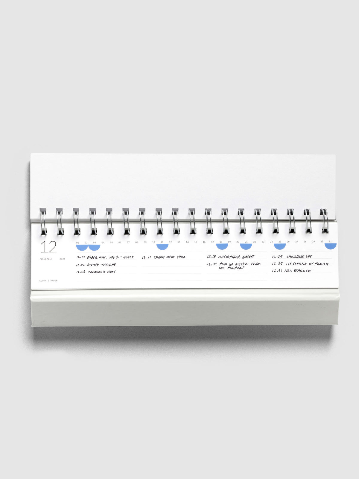 2026 Spiral Desk Calendar shown displaying a calendar page with stickers and handwritten notes.