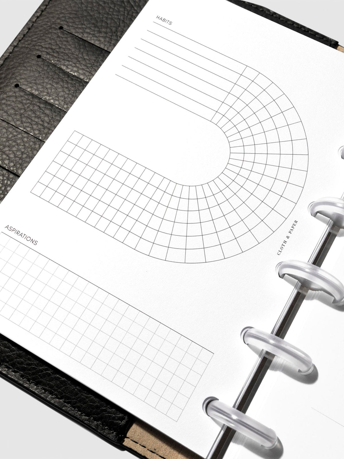 Set of inserts displayed inside a black leather planner.