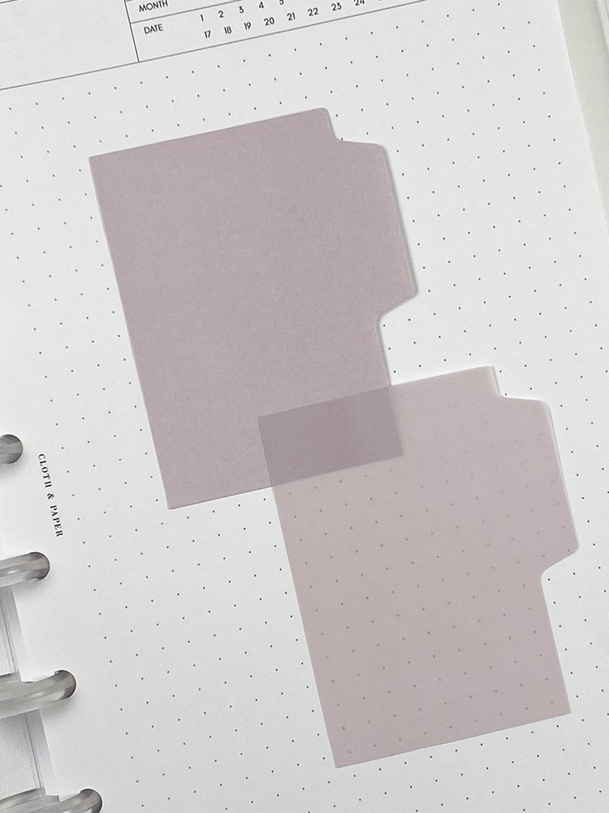 Blank Tab Sticky Note Set, Orchid, Cloth and Paper. One matte and one transparent sticky note from the set placed on a task insert. The transparent sticky note is layered over the bottom right corner of the matte sticky note.