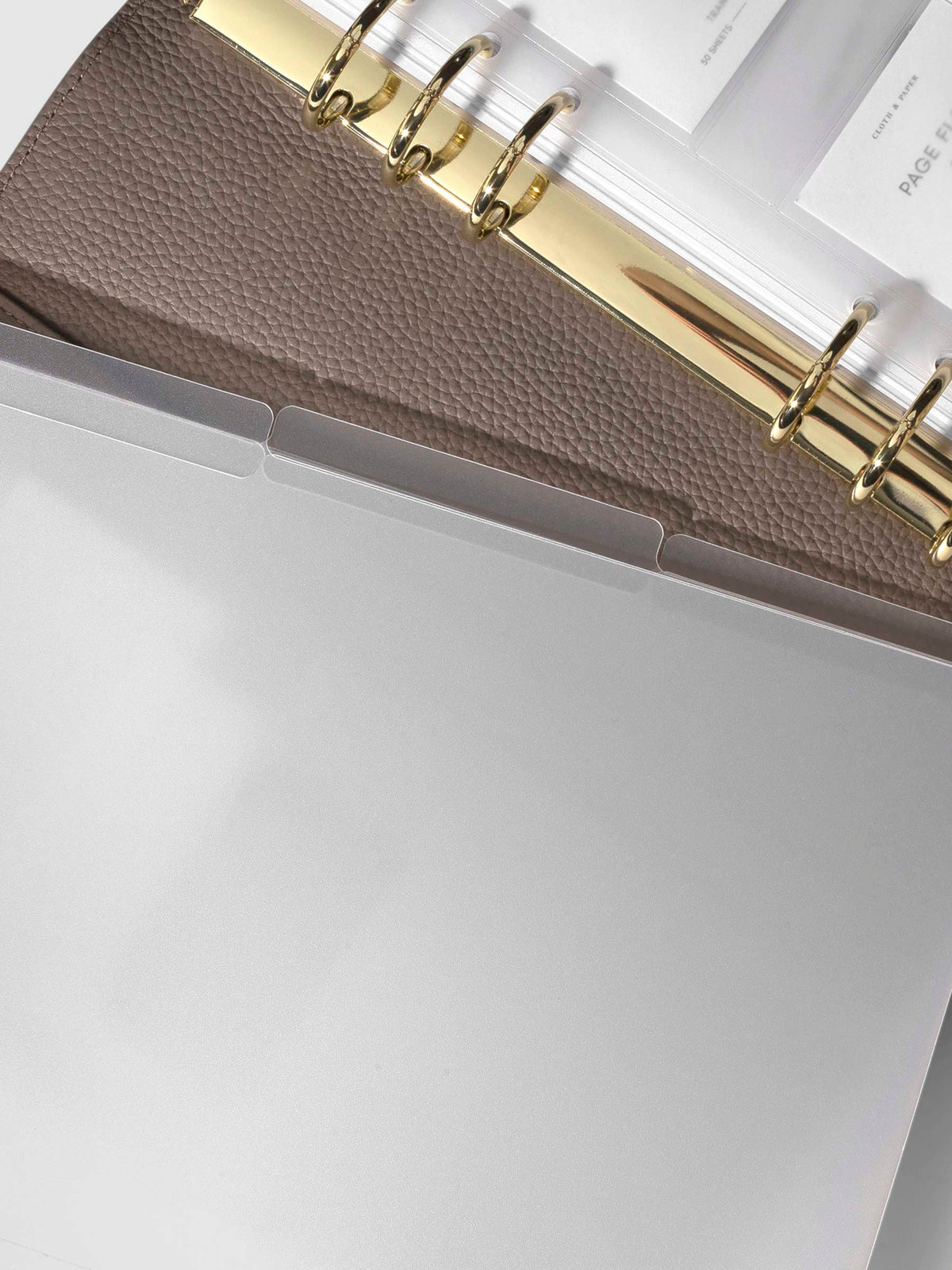 3 folders layered over each other placed on top of a fossil leather agenda.