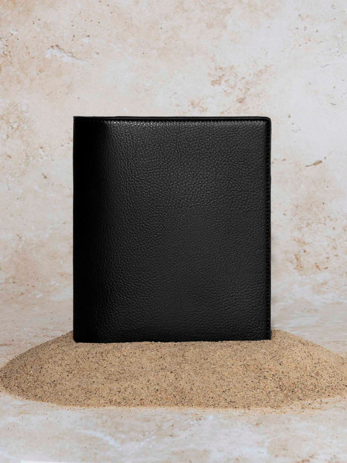 Cactus Vegan Leather Folio, HP Mini, Cloth and Paper. Folio displayed on a textured tan background, placed in a pile of sand. Color pictured is mesa black.