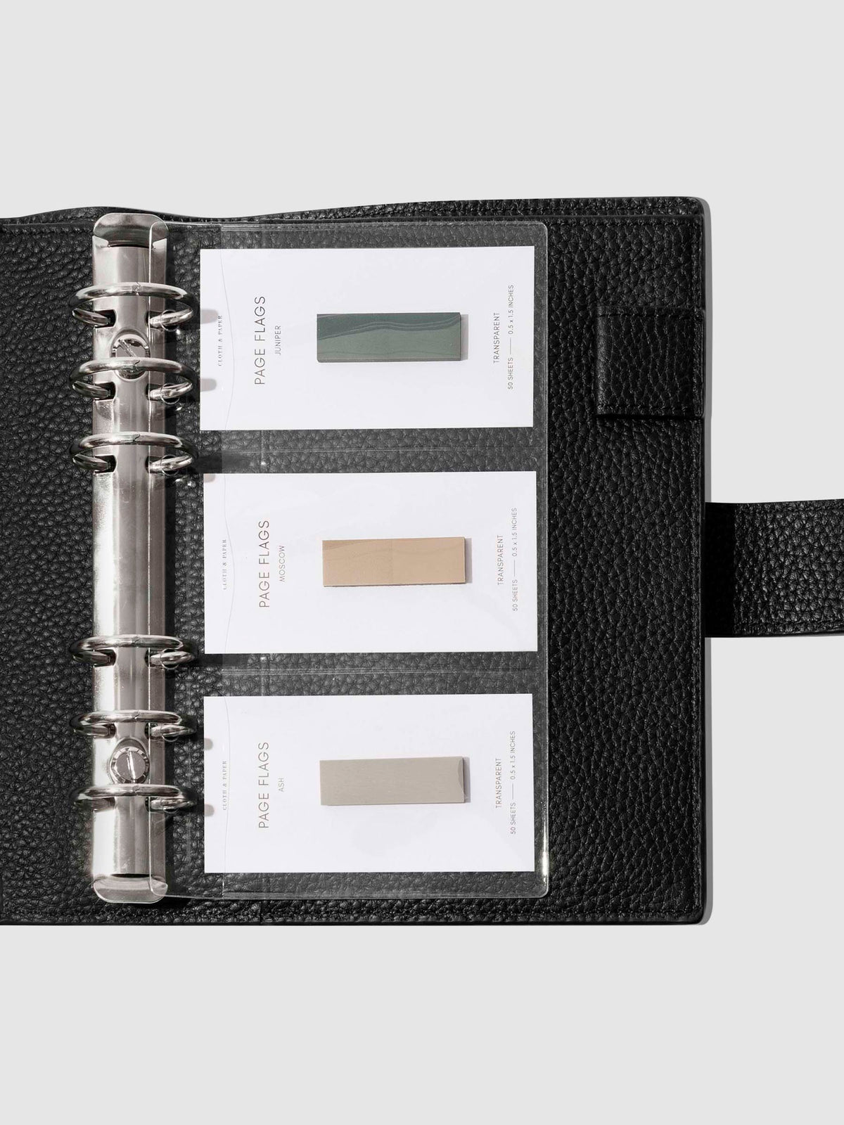 Credit card holders in use inside a black leather folio. Page flags are stored in the open pockets. Size shown is Personal. 