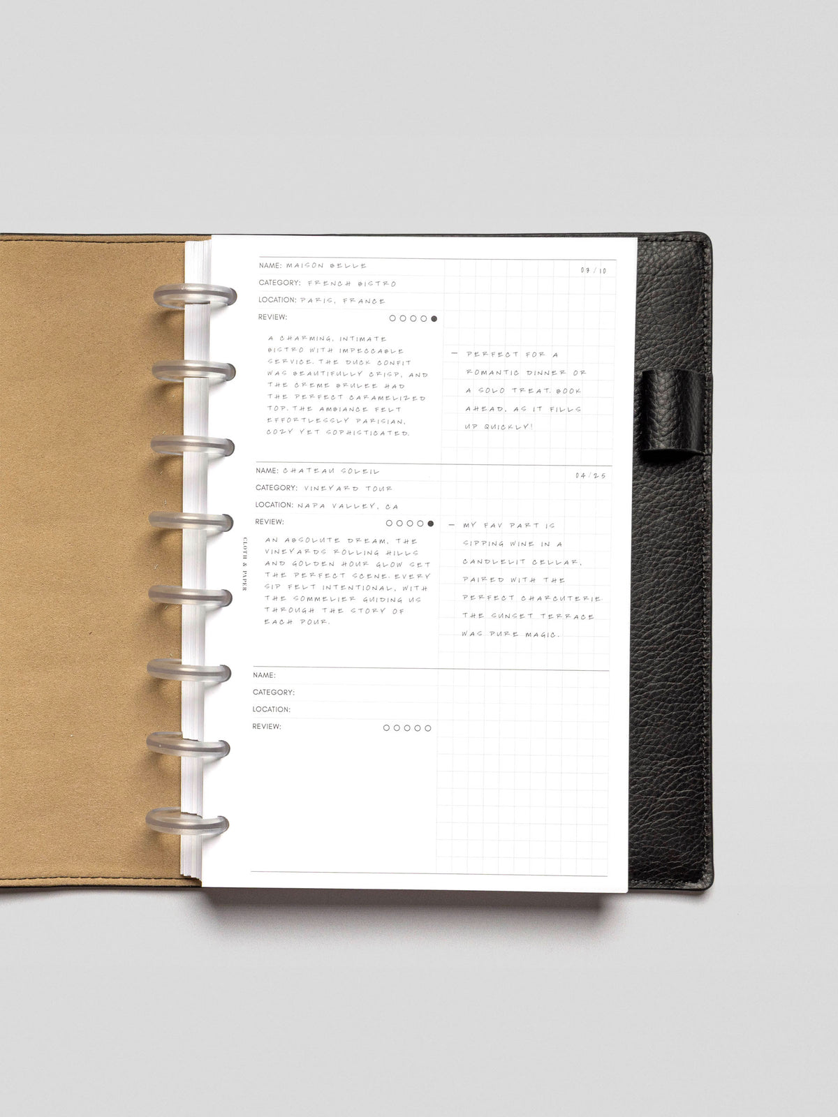 Experience Tracker Insert demo page in Half Letter size inside a planner, showing two logged entries, including a restaurant and a vineyard. A date is written in the corner, and the right grid columns include short reflections.