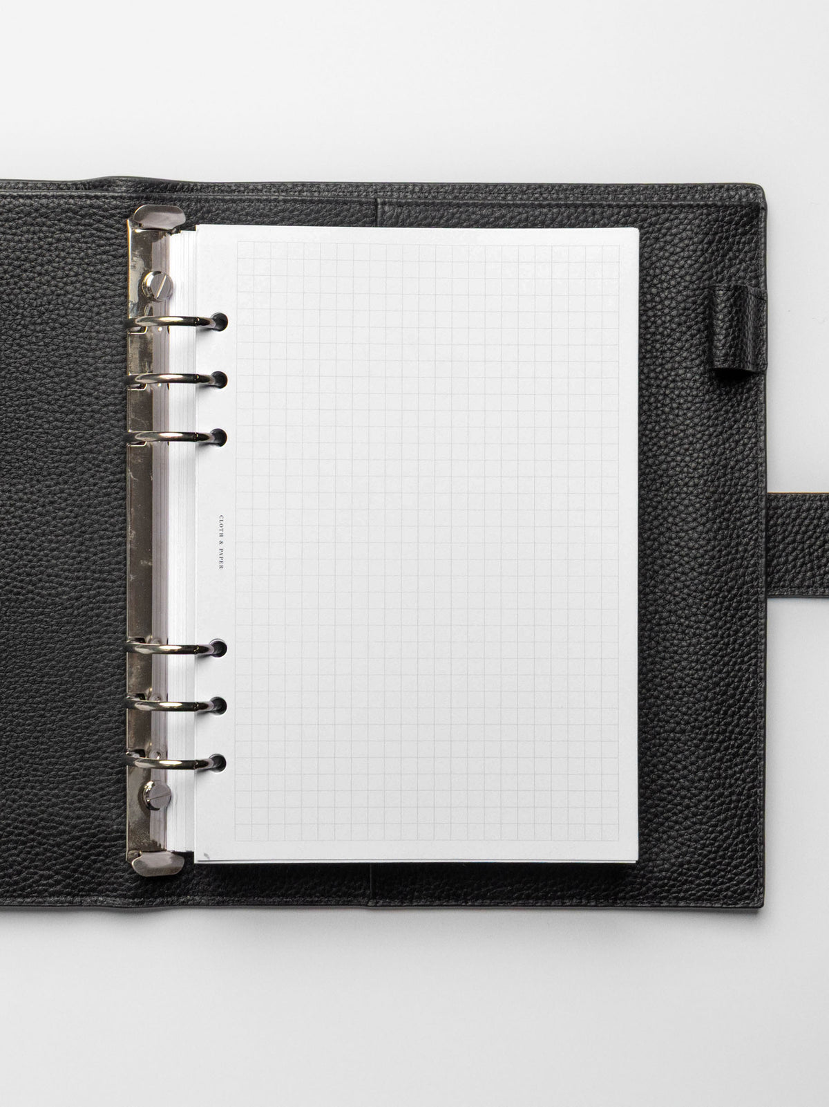 A5 planner with silver rings in a black leather agenda featuring graph note inserts.
