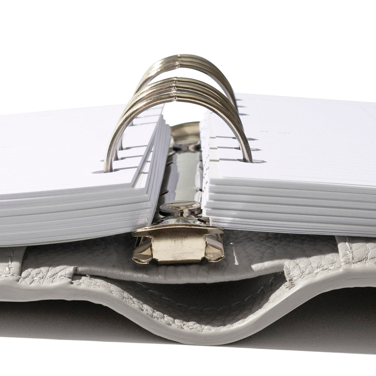 A Foundations Leather 6-Ring Agenda in color Ash is opened showing the rings with planner inserts layered inside.