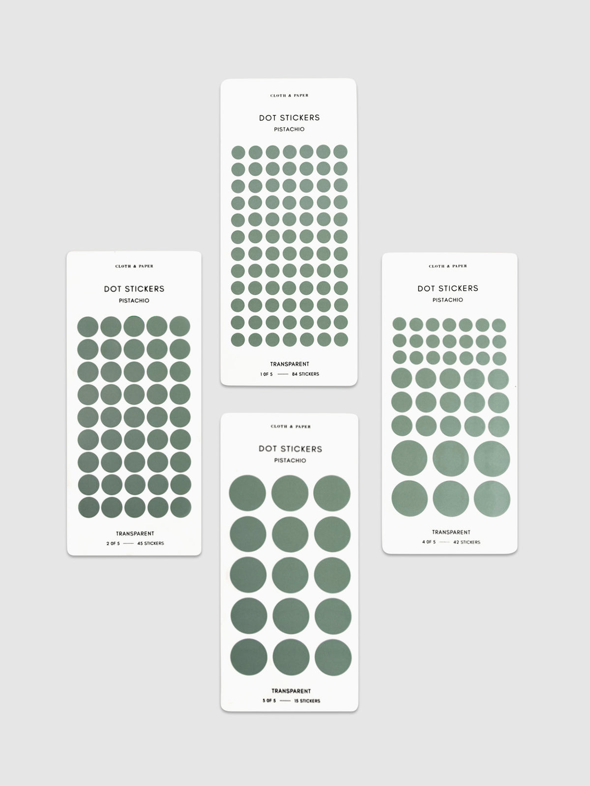 Four sheets of Pistachio dot stickers with varying sizes placed parallel to each other on a neutral background.
