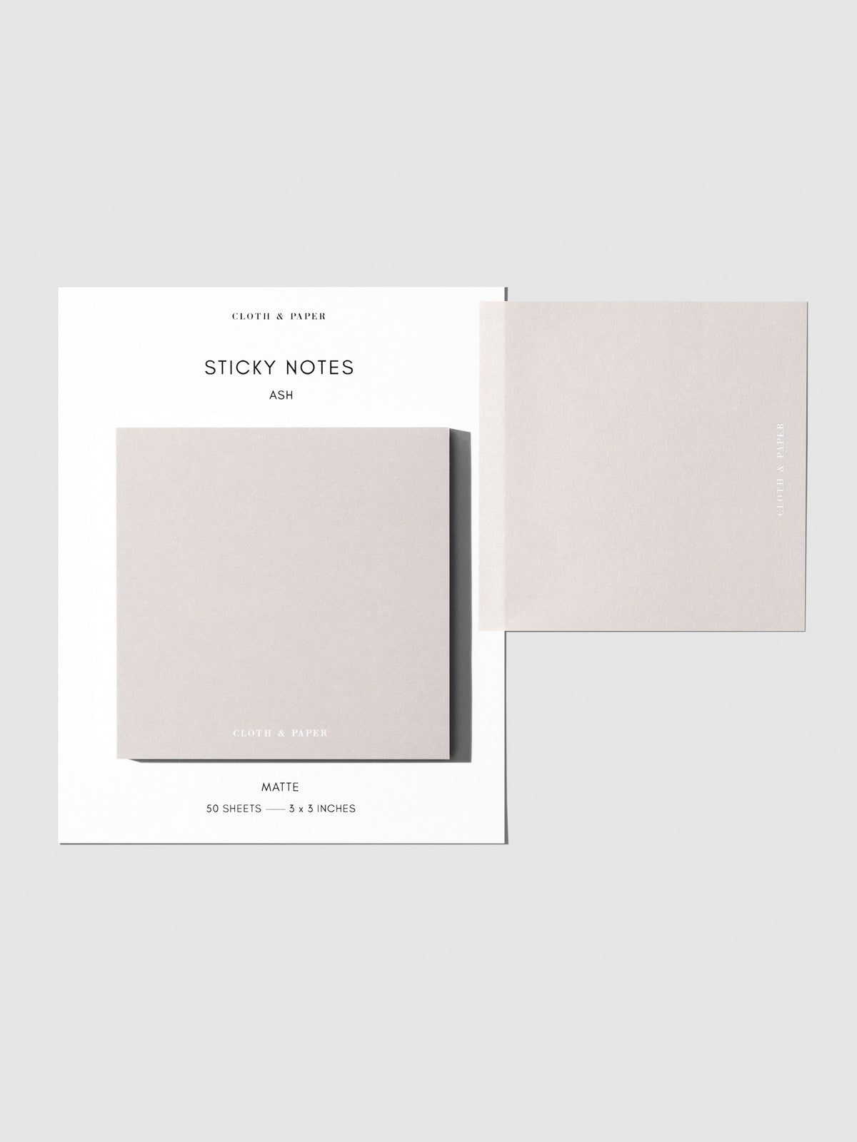 Sticky note set displayed against a neutral background. One note is placed on the packaging's edge. Color shown is Ash.