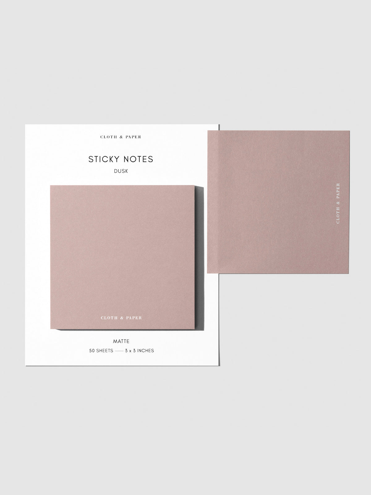 Sticky note set displayed against a neutral background. One note is placed on the packaging's edge. Color shown is Dusk.