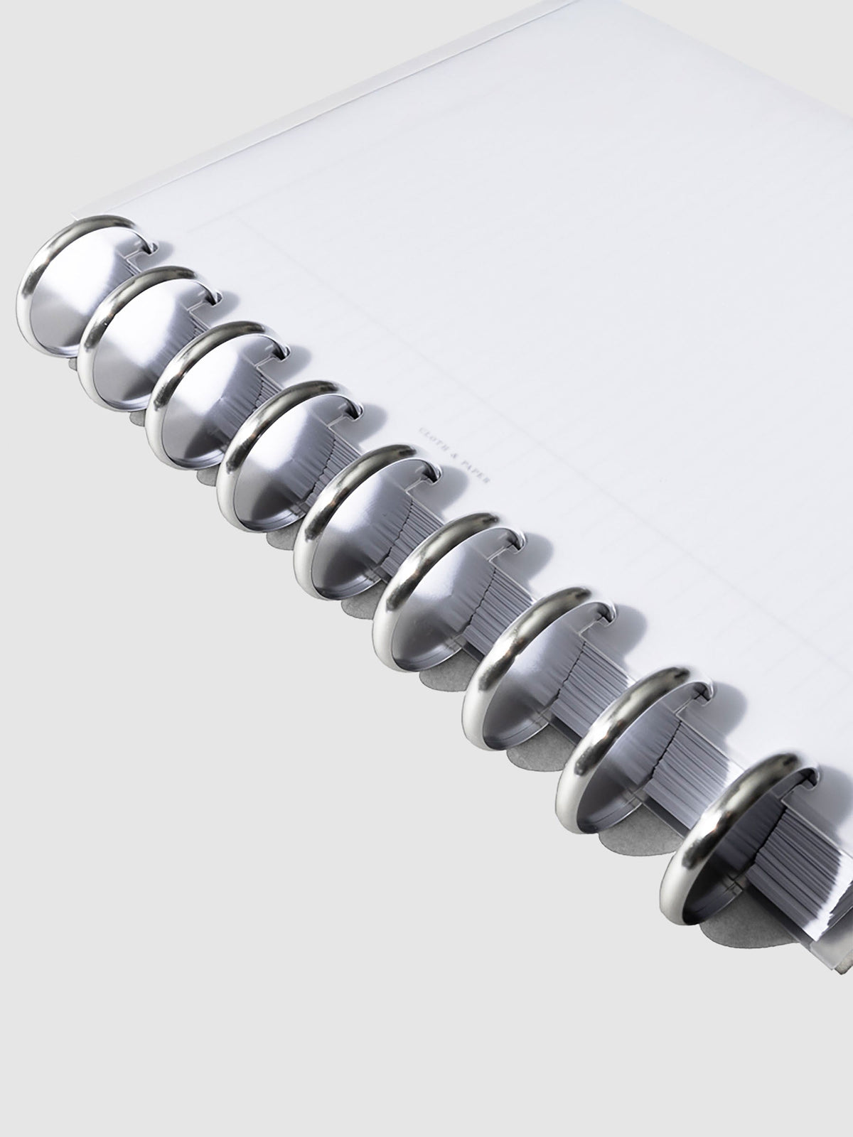 Close-up of silver aluminum planner discs, 1.5 inch size, set of nine stacked together.