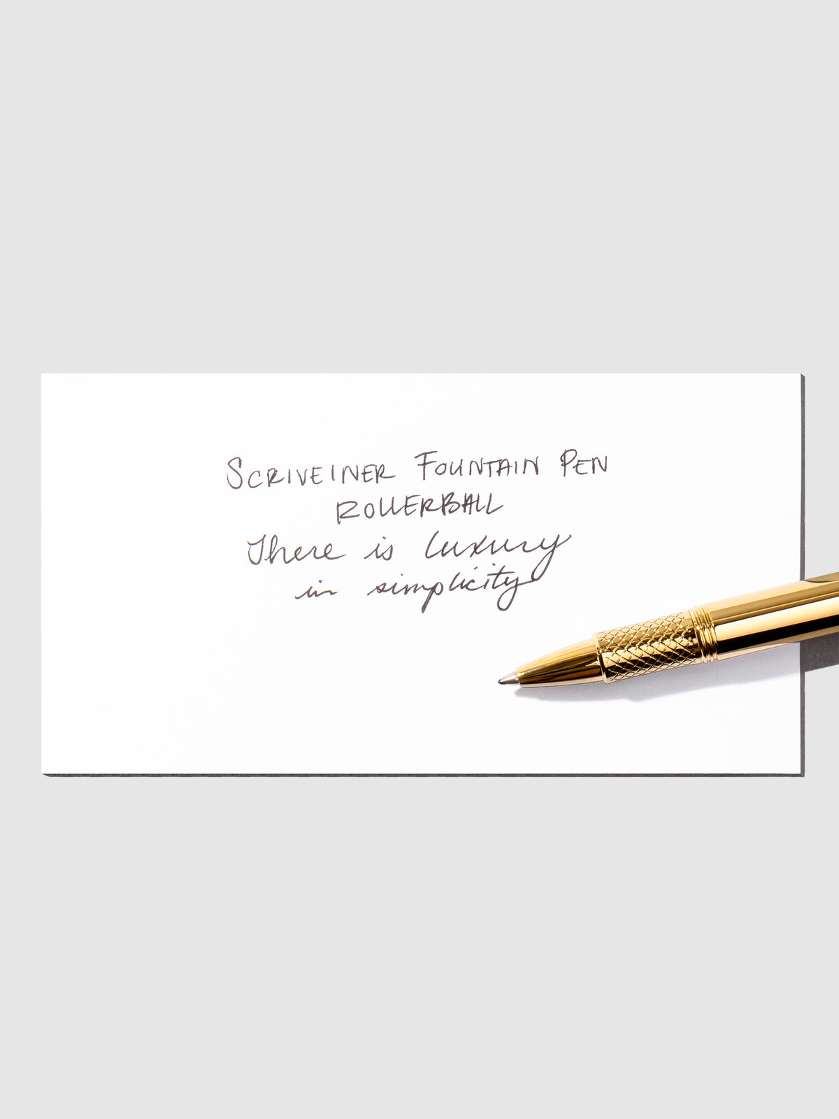 Writing sample displayed with pen on a neutral background.