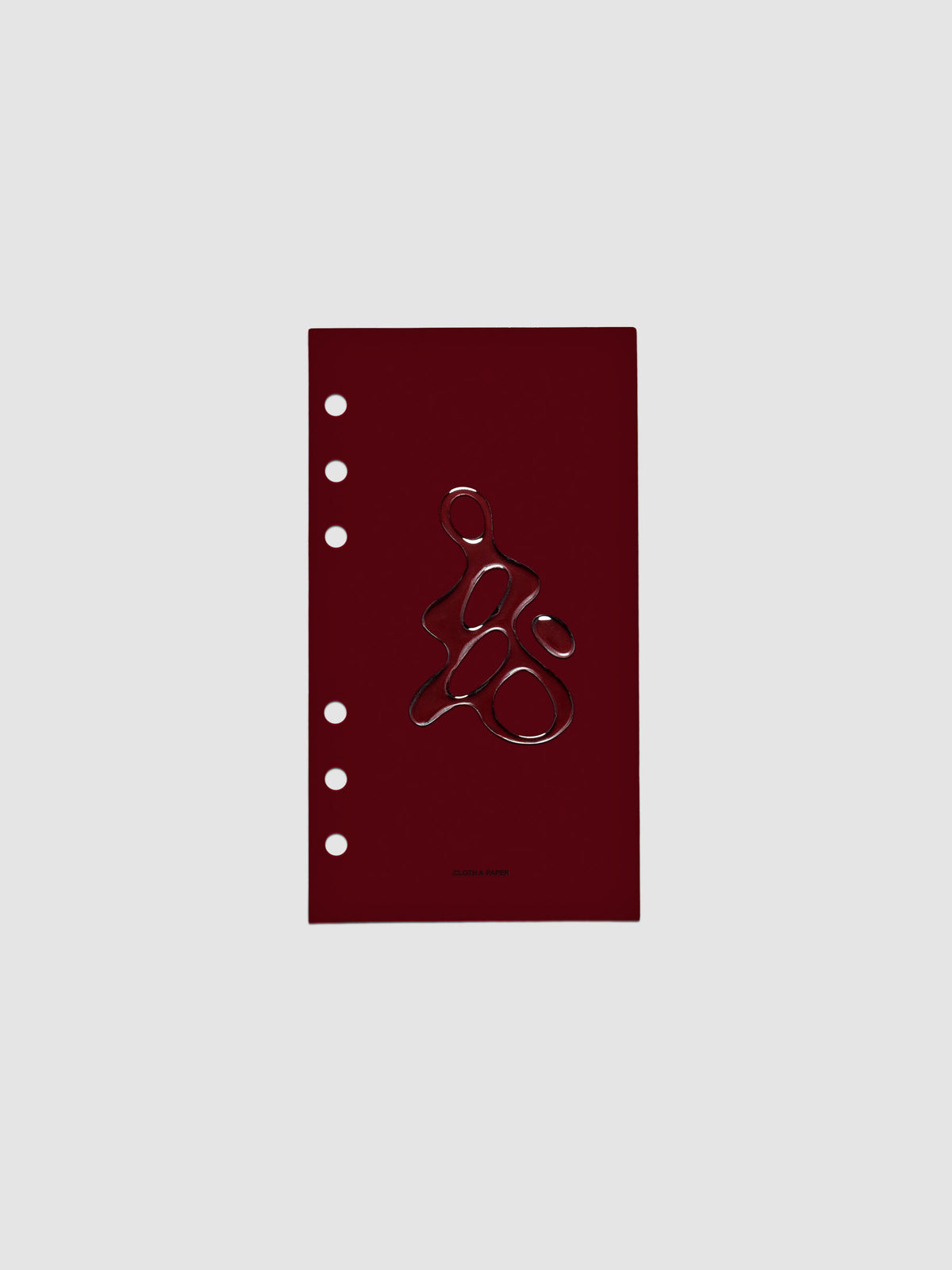 Dark red, semi-transparent, and glossy plastic planner dashboard with organic raised shape design in size Personal on a neutral background.