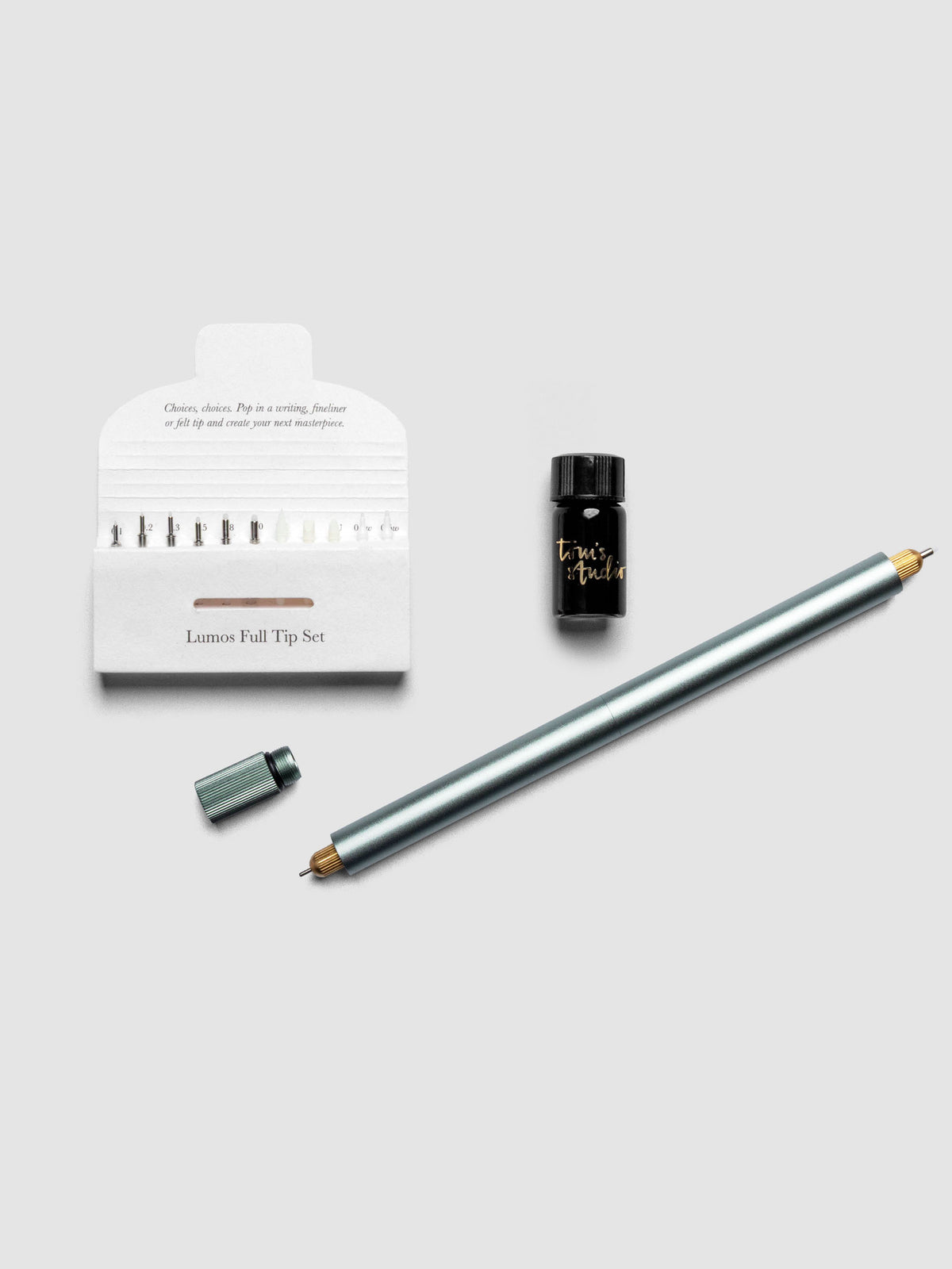 Sage Green Lumos Pro Duo Tip Pen resting diagonally on an open notebook, uncapped, shown with tips set and ink.