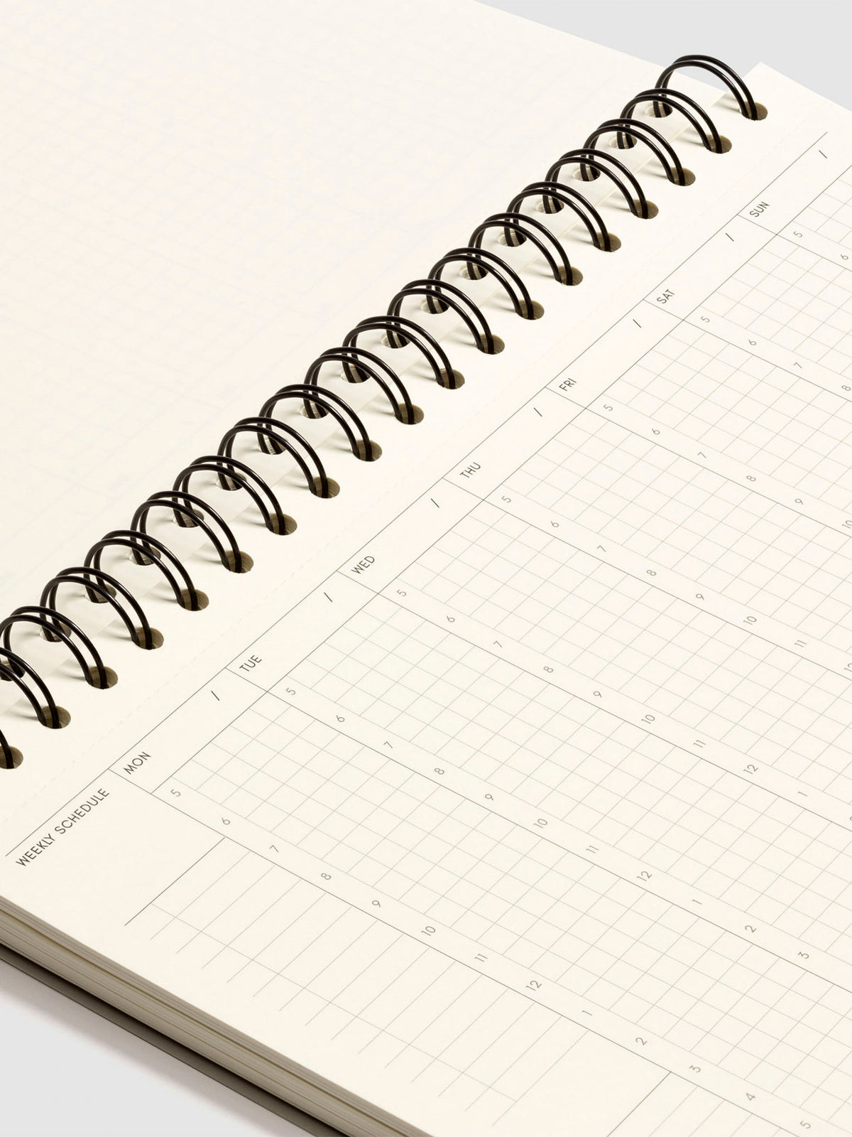 Close up of the spiral binding of the notebook and weekly schedule page.