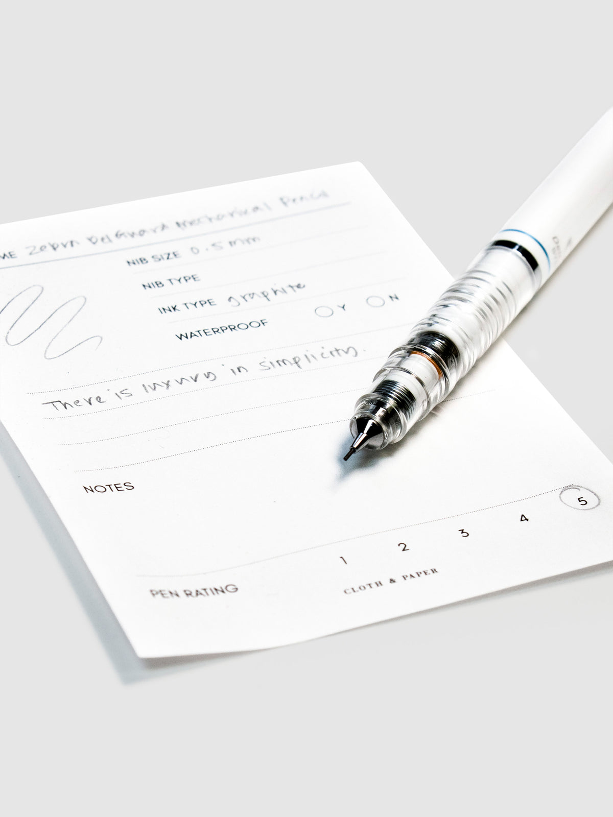 Close up on pencil nib with lead resting on its pen test sheet.