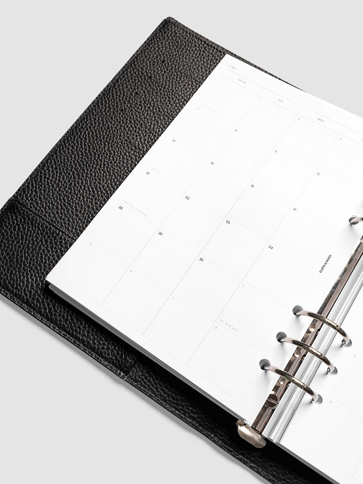2027 Dated Monthly Planner Inserts, Monday Start, A5 6-Ring Punch, close-up detail of left page showing holidays and observances labeled on monthly calendar shown inside a planner